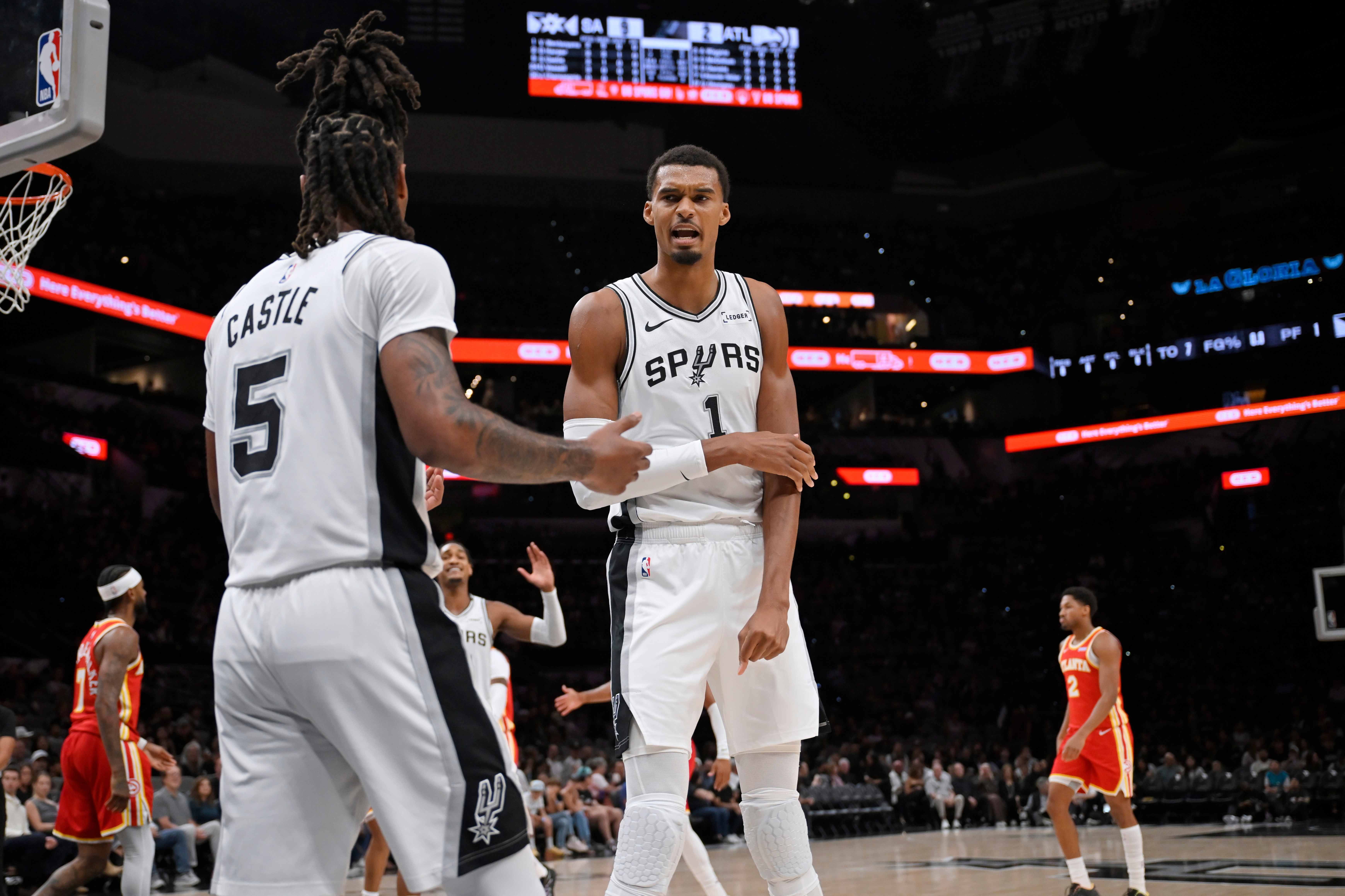 San Antonio Spurs players Victor Wembanyama (1) and Stephon Castle (5) speak after a play during a preseason NBA basketball game against the Atlanta Hawks, Thursday, Oct. 8, 2026, in San Antonio. (AP Photo/Darren Abate)