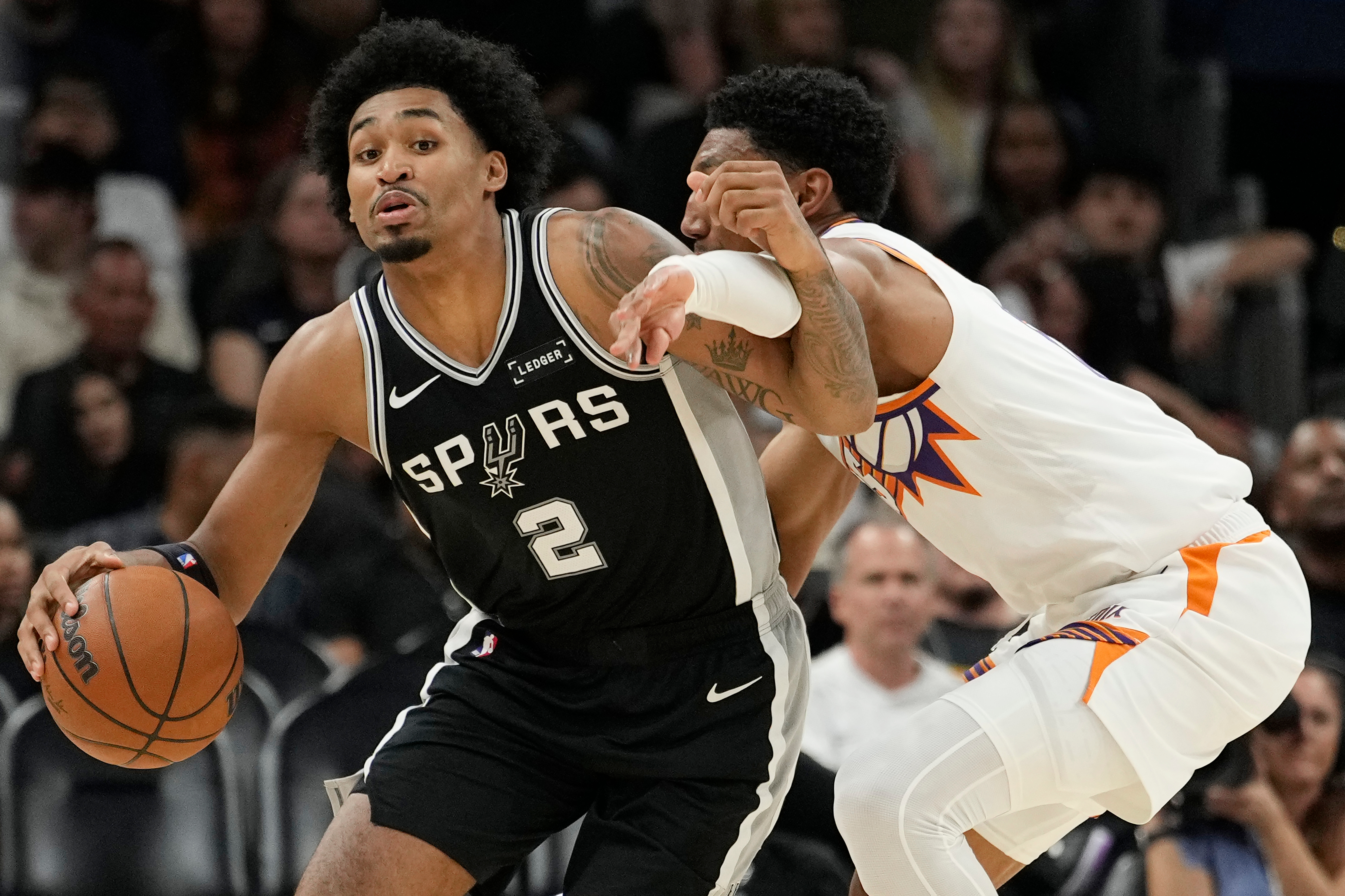 San Antonio Spurs guard Dylan Harper (2) gets fouled by Phoenix Suns forward Ryan Dunn during a preseason NBA basketball game, Saturday, Oct. 10, 2026, in Phoenix. (AP Photo/Ross D. Franklin)