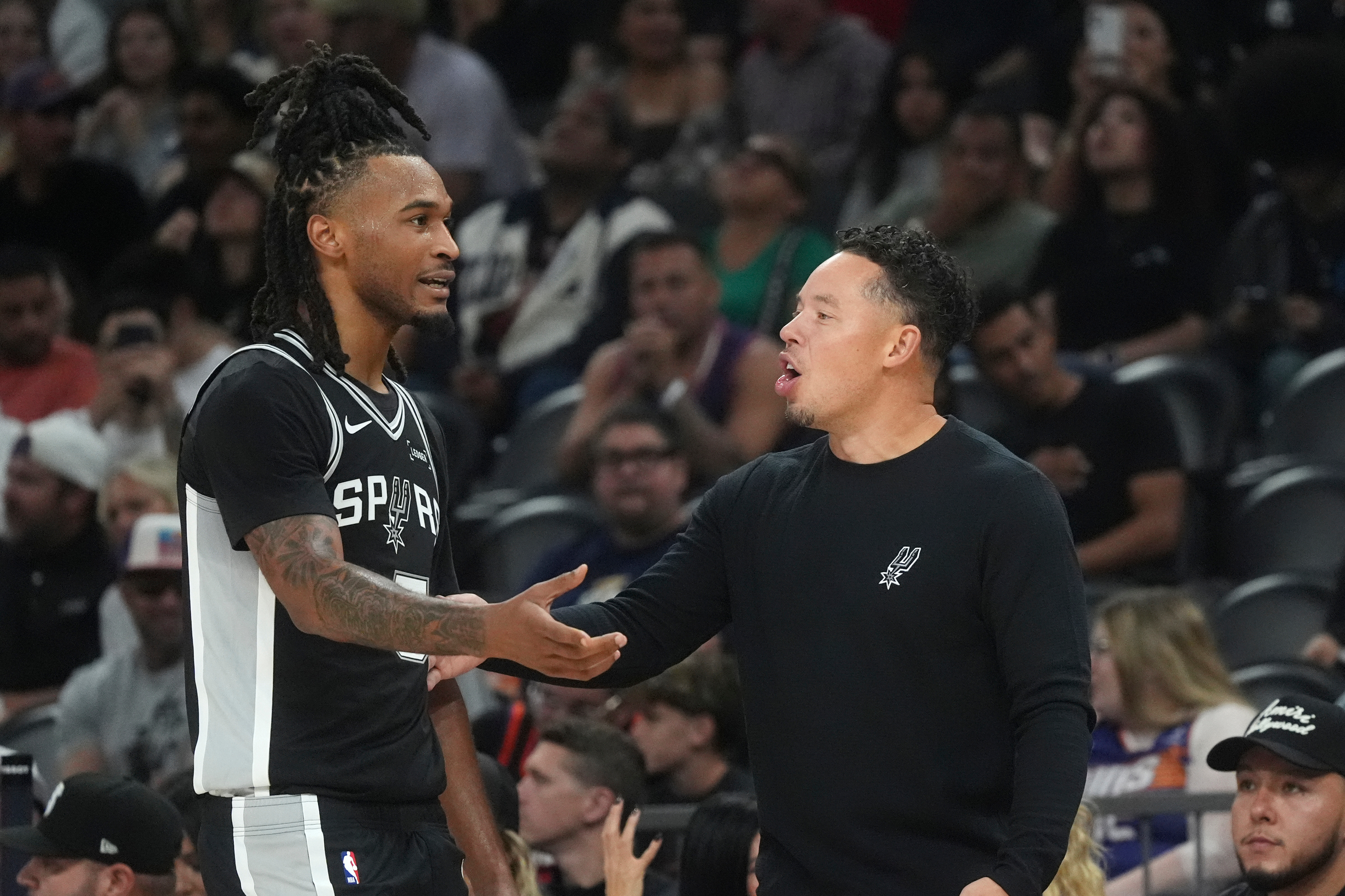 San Antonio Spurs head coach Mitch Johnson, right, talks with Spurs guard Stephon Castle during a preseason NBA basketball game against the Phoenix Suns, Saturday, Oct. 10, 2026, in Phoenix. (AP Photo/Ross D. Franklin)