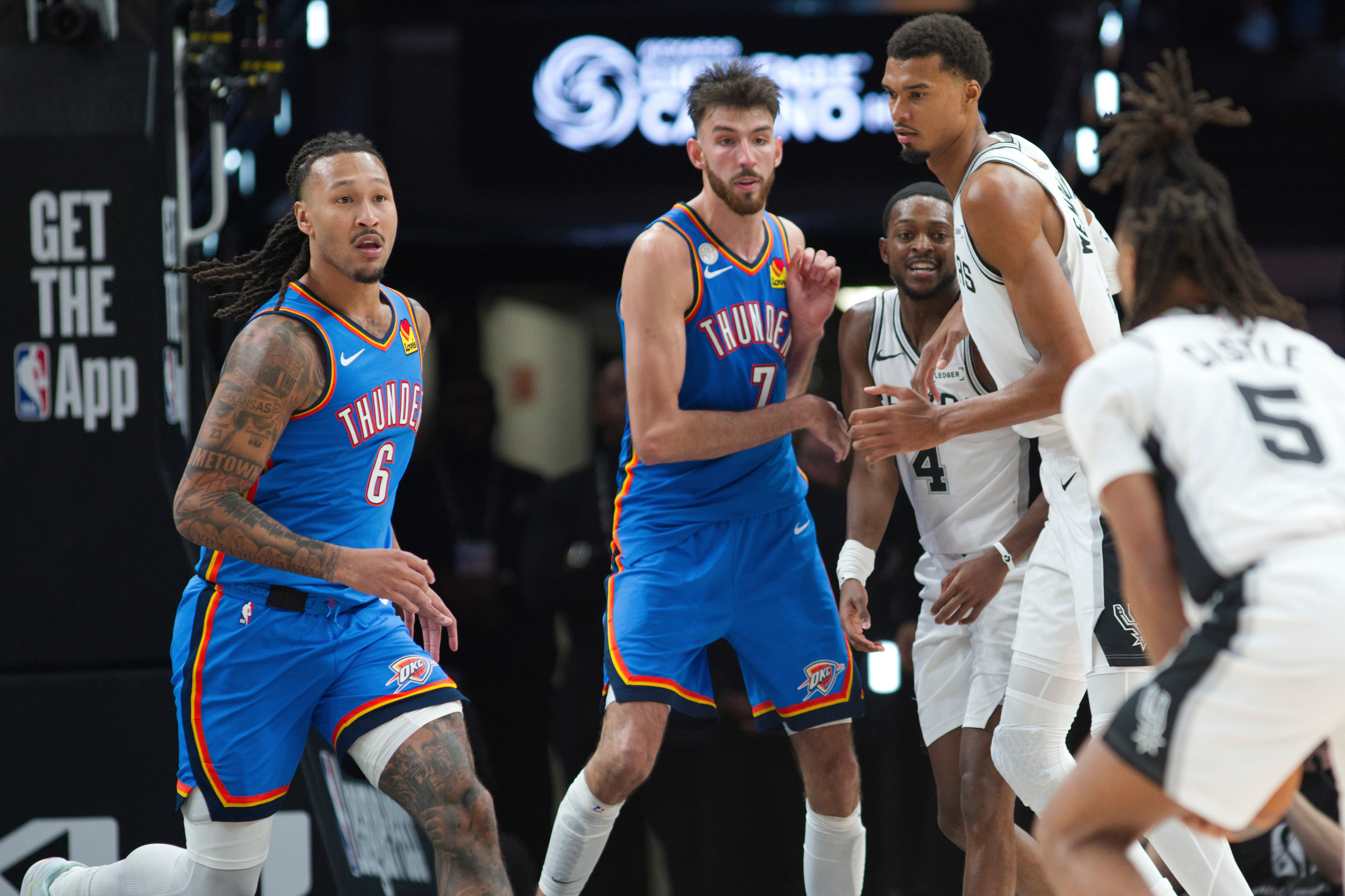 Oklahoma City Thunder forward Jaylin Williams (6) moves to defend against San Antonio Spurs guard Stephon Castle (5) during the second half of an NBA basketball game, Tuesday, Oct. 20, 2026, in San Antonio. (AP Photo/Darren Abate)